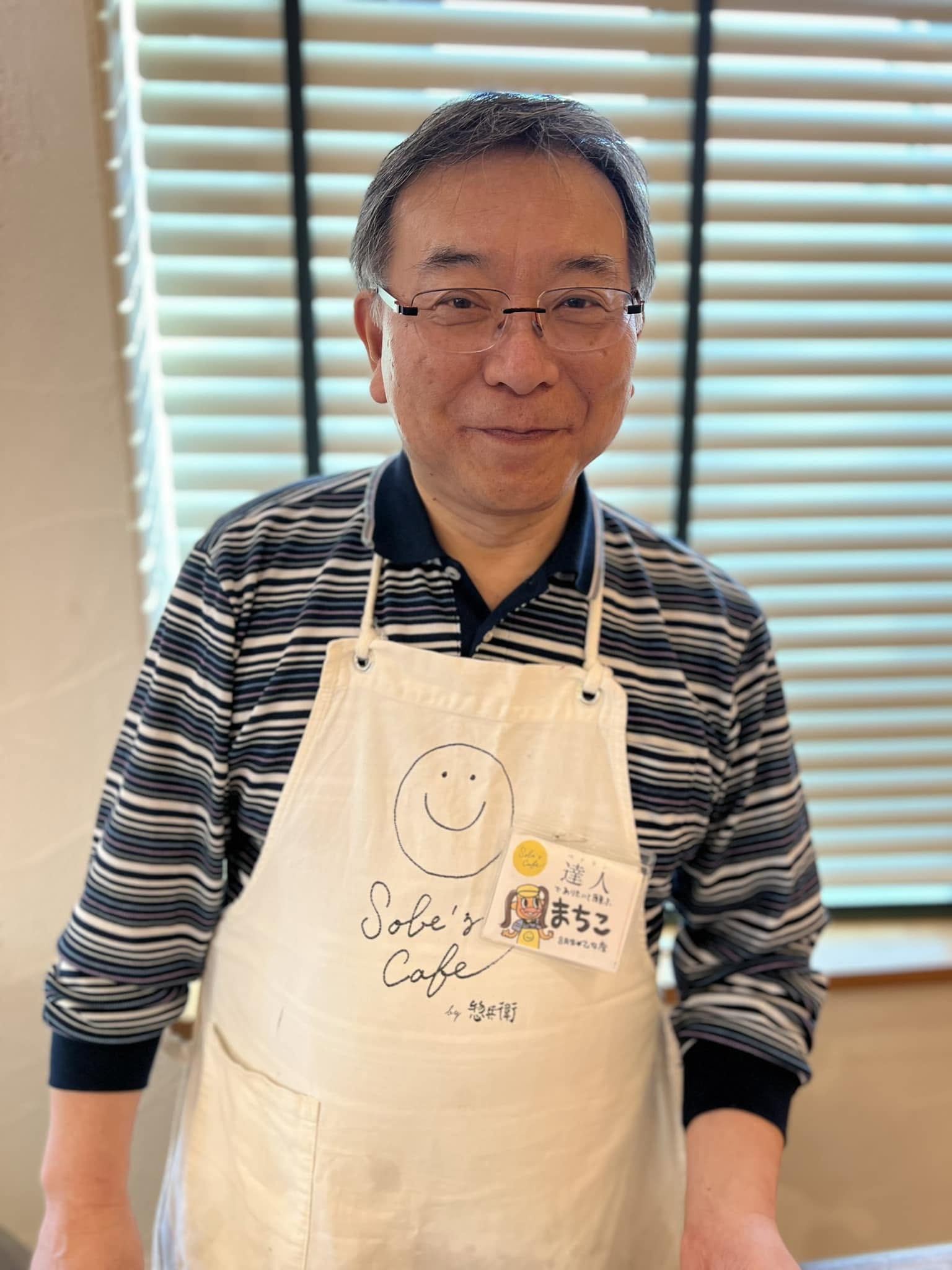 Sobe'sCafeのエプロン姿で微笑む下町壽男さん